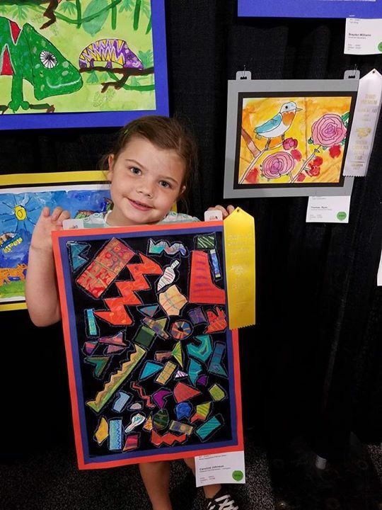 student showing winning artwork