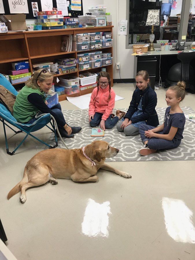 students reading with therapy dog